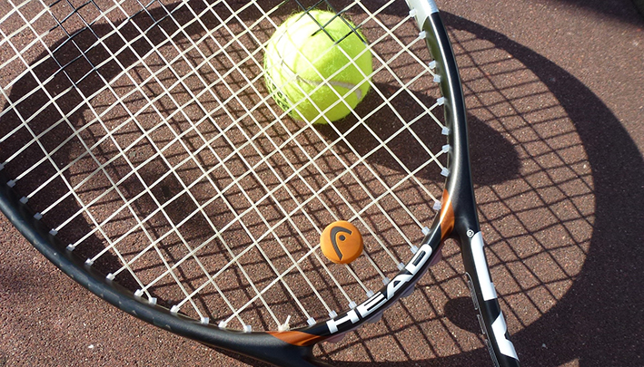 Tennisracket och en boll