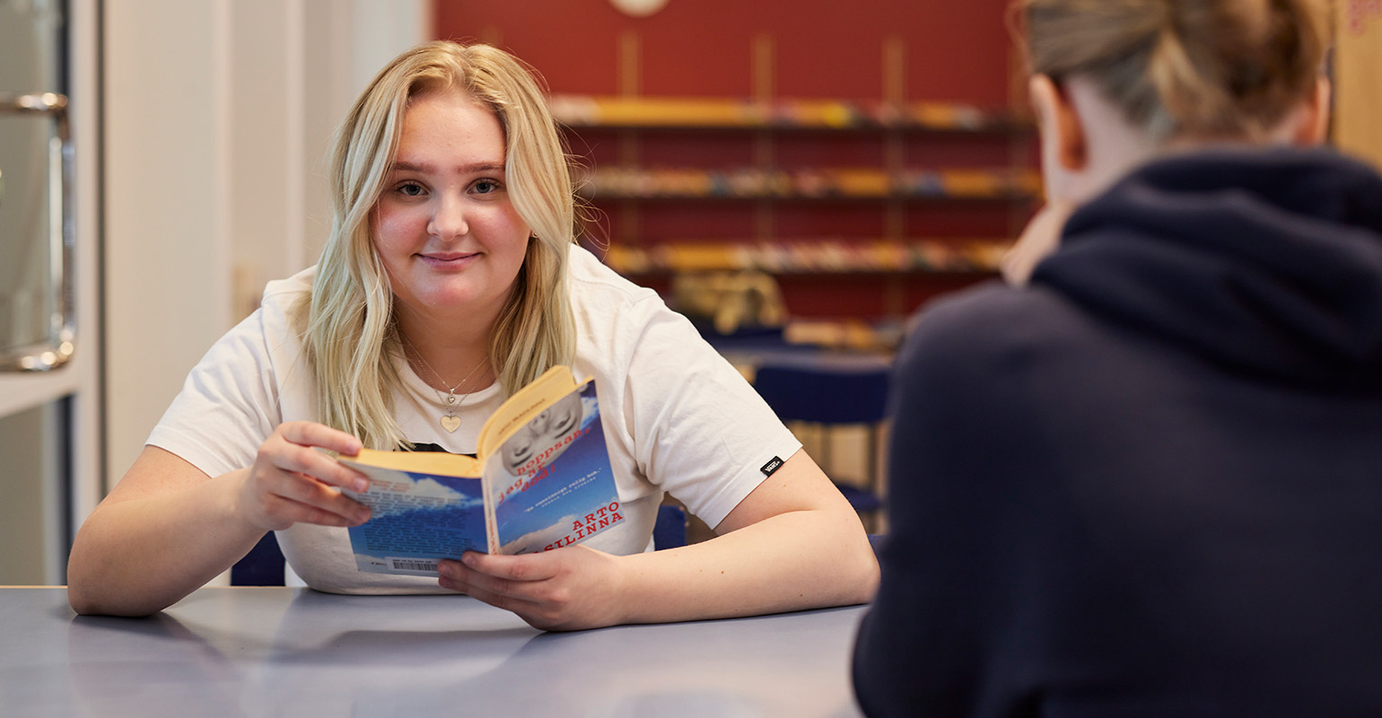 Elev som läser bok på biblioteket på Lagmansgymnasiet.