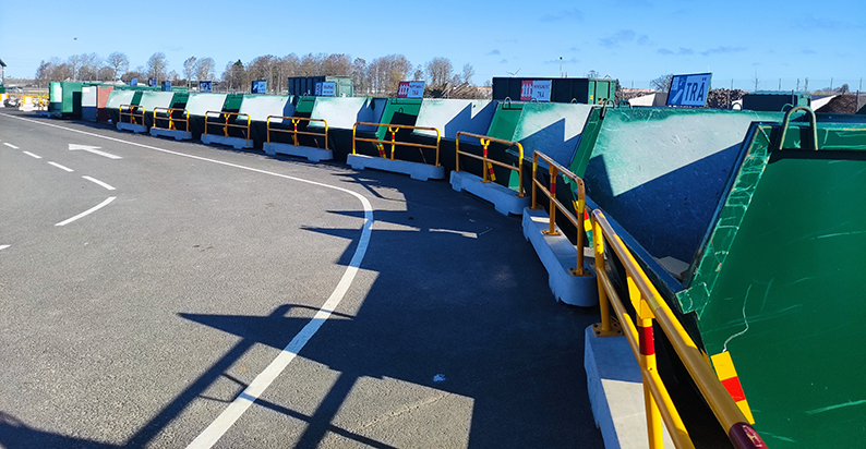 Gröna containrar för återvinning står på rad