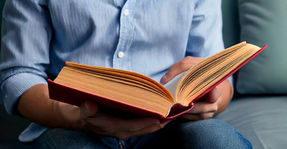 En person läser ur en bok