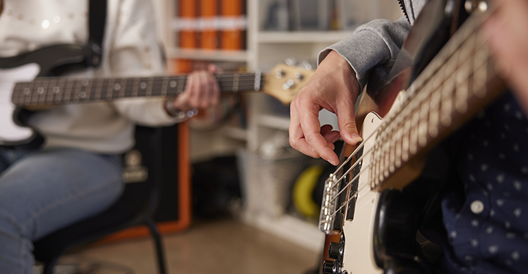 En person som spelar gitarr och en som spelar bas